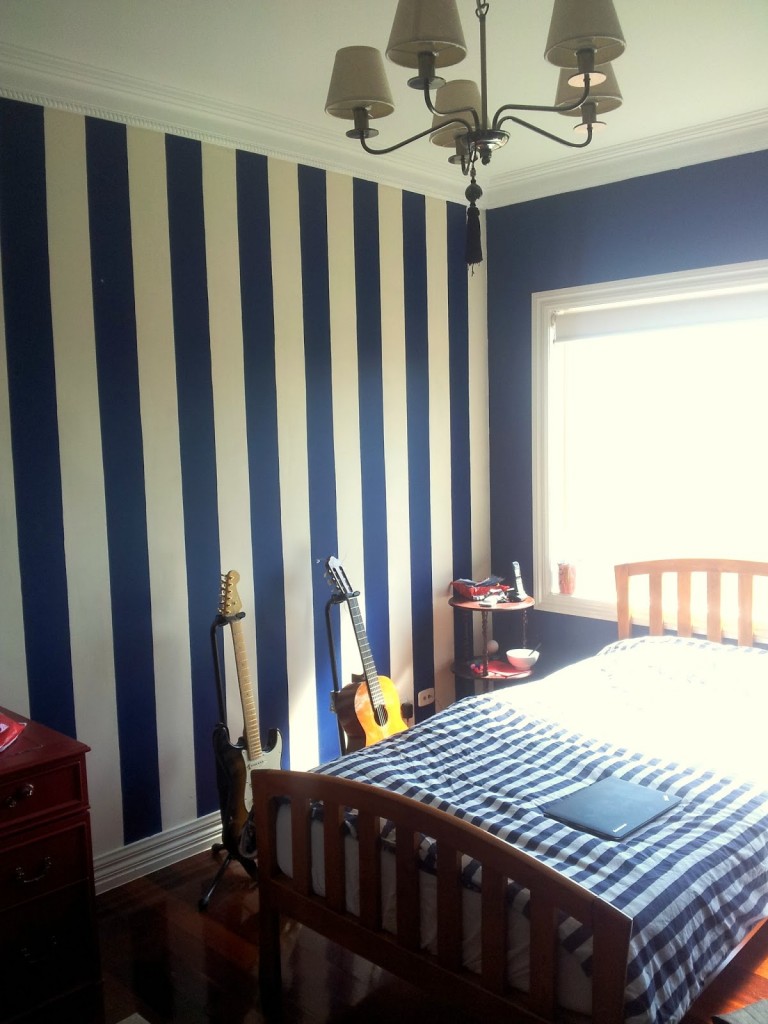 other-design-classy-brushed-bronze-ceiling-lighting-over-blue-quilt-rail-headboard-bed-and-blu-striped-wall-decals-as-decorate-in-guys-navy-blue-bedroom-ideas-soothing-navy-blue-bedroom-with-wall-deco