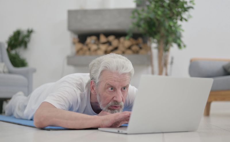 stariji čovek gleda u laptop